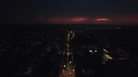 Lightning striking dark stormy sky over city street. Magic aerial view drone Stock Footage 344612509