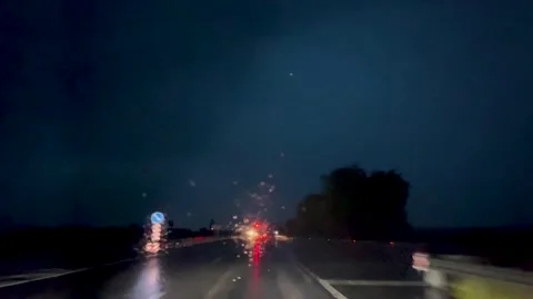 Lightning, thunderstorm and rain in the dark sky. View from the window of a Stock Footage 247912356