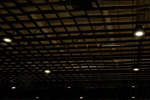 Lights and ventilation system in long line on ceiling of the dark office indu Stock Photos