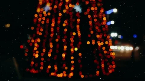 The lights of a decorated tree blurred, in the city, cars. Stock Footage 145197676