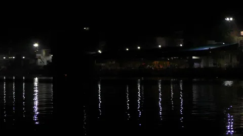 Lights falling on water from far away sources and flickering on it. Video stock 126768780