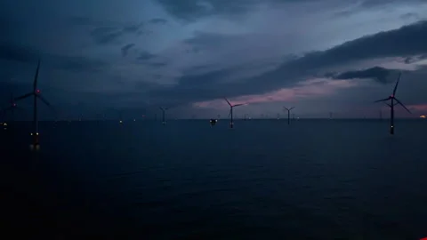 Lights flicker over turbulent waters, Distant silhouette of offshore windmills 스톡 동영상 327417450
