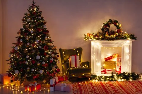 Lights garland Christmas tree with gifts interior new year night Stock Photos