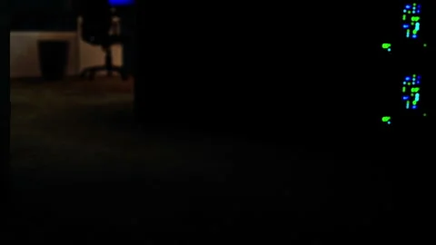 Lights glow from computer equipment in a dark room during late night work 動画素材 345003506