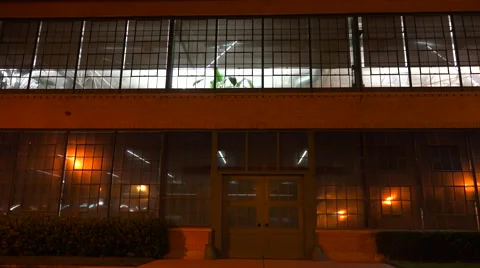 Lights glow inside a warehouse or factory at night. Stock-Footage 46833697