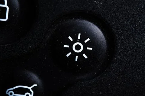 The lights icon button is close on the digital car key device. Old and dirty Stock Photos