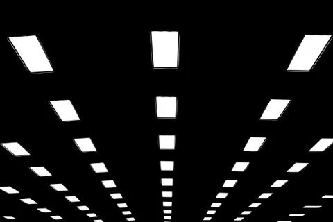 Lights in long line on ceiling of the dark office building Stock Photos