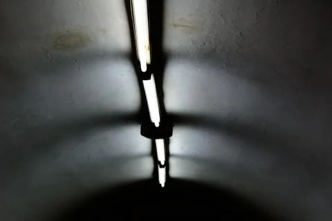 Lights in long line on ceiling of the dark building Stock Photos