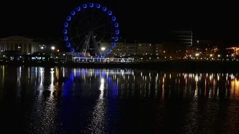 The lights of the night city are reflected in the water of the river. Stock Footage 282867148