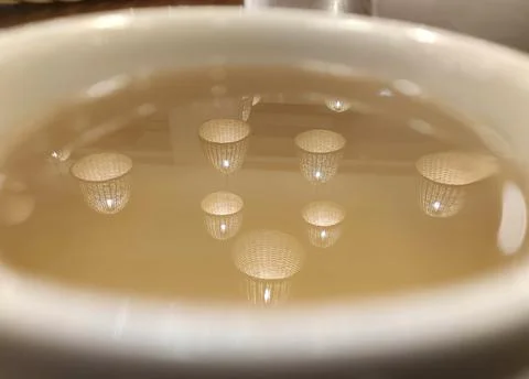 Lights reflection in a cup of tea background Stock Photos