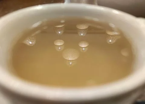 Lights reflection in a cup of tea background Stock Photos