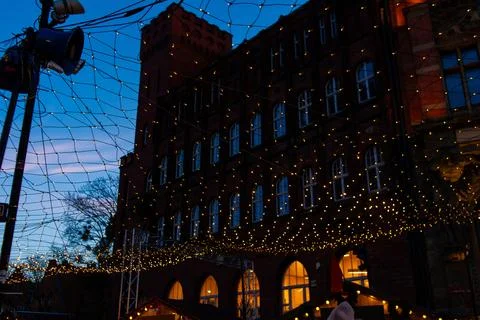 Lights shine on building during evening event in downtown area Stock Photos