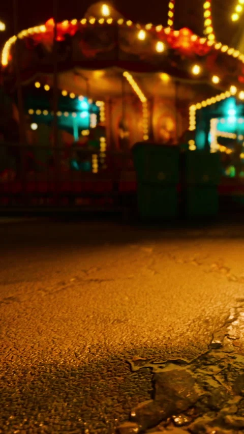 Lights shine on the empty street near the amusement ride at night Stock Footage 341045672