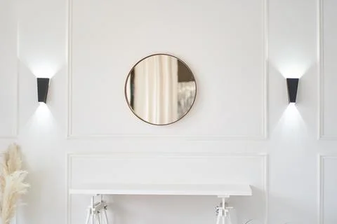 Lights on the wall next to a small table and the mirror. Part of the interior Stock Photos