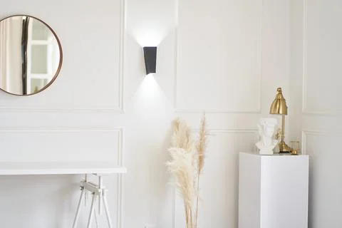 Lights on the wall next to a small table and the mirror. Part of the interior Stock Photos