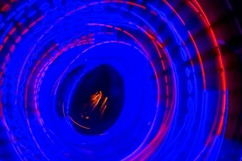 Lightsaber fun in the dark . Deep blue round pattern with red streaks . Stock Photos