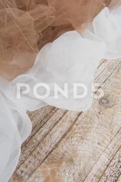 Lightweight fabric mesh lace on textured wooden table. Texture of the fabric Stock Photos
