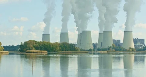 Lignite-fired power station in front of a lake, a flock of birds starts Stock-Footage 100515454