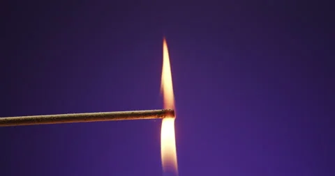 Ligniting an incense stick with fire on an isolated purple background. Macro Stock Footage 146166949