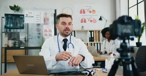 Likable confident smart qualified bearded doctor sitting at his workplace in Stock Footage 159787235