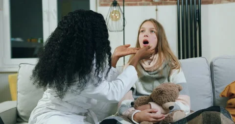 Likable experienced careful black-skinned female private doctor checking teen Stock Footage 144683387