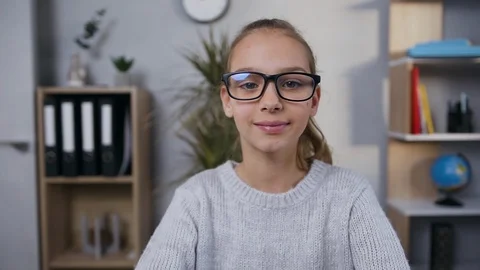 Likable friendly smiling 15-aged girl in glasses posing on camera on the Stock Footage 124542341