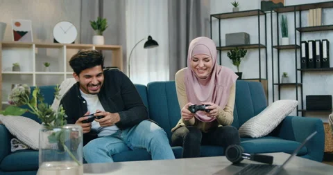 Likable funny 30-aged arabian couple having fun together while playing video Stock Footage 150109628