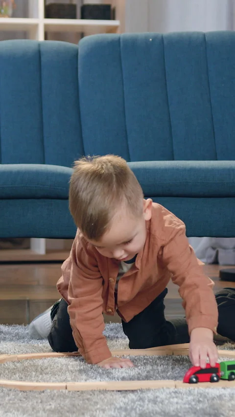 Likable in good mood 8-aged and 10-aged boys sitting on the fluffy carpet and wa Stock Footage 328834986