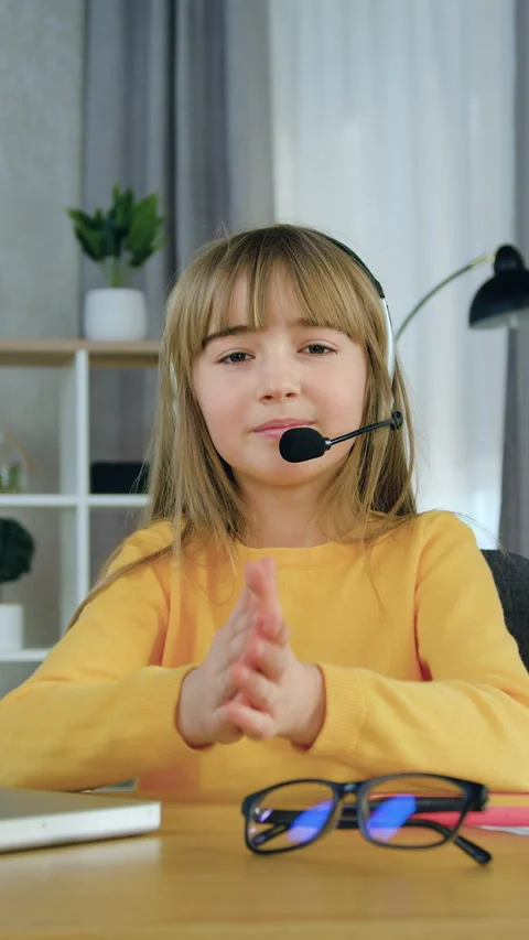 Likable in good mood confident smart primary schoolgirl in headphones looking in Stock Footage 332736960