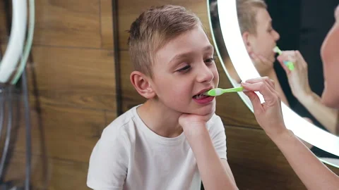 Likable high-spirited 10-aged blond boy sitting near the bathroom mirror with Stock Footage 131235001