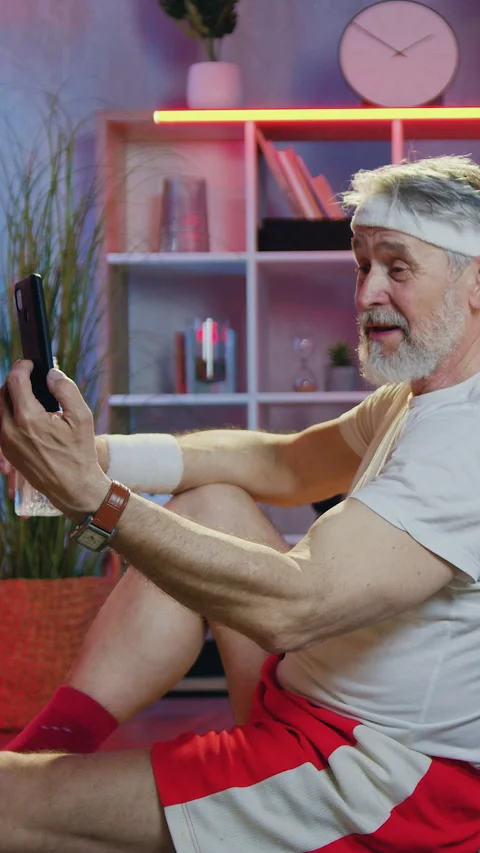 Likable joyful young bearded guy working with dumbbells while his sportive matur Stock Footage 330662464