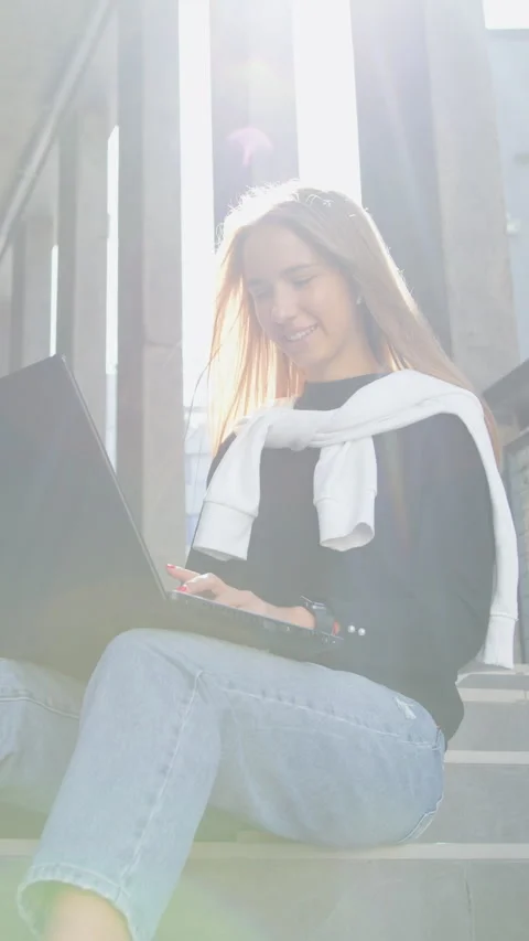 Likable modern cheerful 20-25-aged blondie in black sweater and jeans relaxing o Stock Footage 330181532