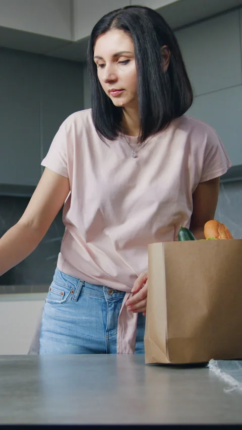 Likable positive 30-aged brunette putting on dinner table food paper bag with gr Stock Footage 330063479