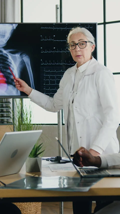 Likable purposeful motivated three multicultural doctors sitting near the table  Stock Footage 332993518