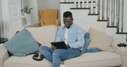 Likable satisfied smiling young black-skinned man in casual clothes resting on Stock Footage 144350096