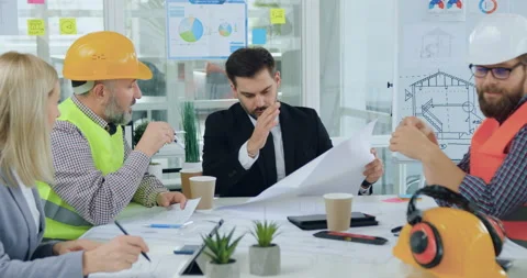 Likable successful bearded manager of building company discussing with his Stock Footage 145599996