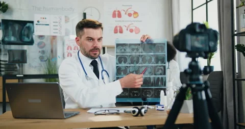Likable successful modern high-skilled bearded doctor explaining x-ray scan for Stock Footage 159790663
