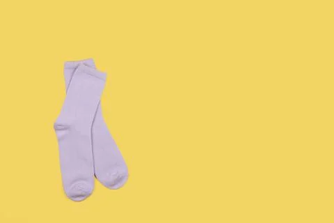 Lilac children's socks without pattern, isolated on yellow background with co Stock Photos