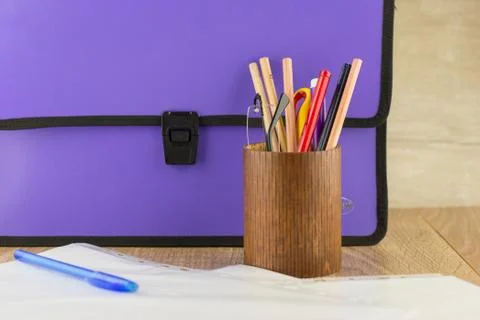 Lilac closed documents folder is on the table, next to the pencil case with g Stock Photos