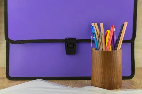 Lilac closed documents folder is on the table, next to the pencil case with g Stock Photos