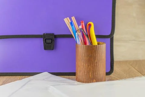 Lilac closed documents folder is on the table back, next to the pencil case w Stock Photos