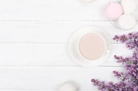Lilac, coffee with latte art on light wooden table. Romantic morning.Flat lay Stock Photos