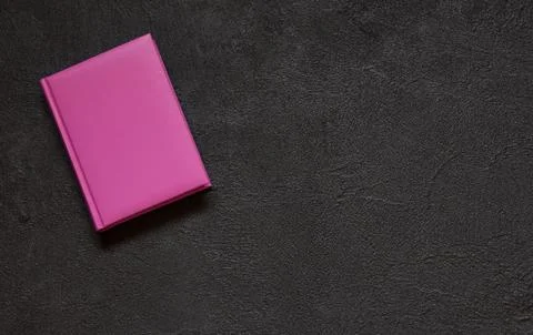 Lilac notepad on black concrete background. Top view. Stock Photos