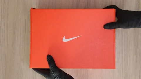 Lima, Peru. March 07 2026; Person in black gloves placing nike shoebox on a Stock Footage 330592906