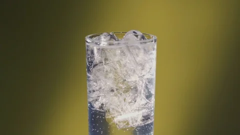 Lime added to a Soda water or a Sprite spinning glass, slow motion bubbles. Stock Footage