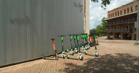 Lime and Spin ride share electric scooters Downtown in a row Stock Footage 114085467
