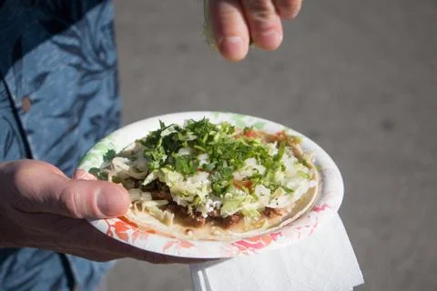 Lime being squeezed onto a taco Stock Photos