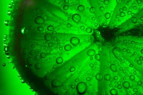 Lime with bubbles on green background Stock Photos