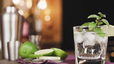 Lime cocktail with mint and ice on the background of the bar. Stock Footage 106803547
