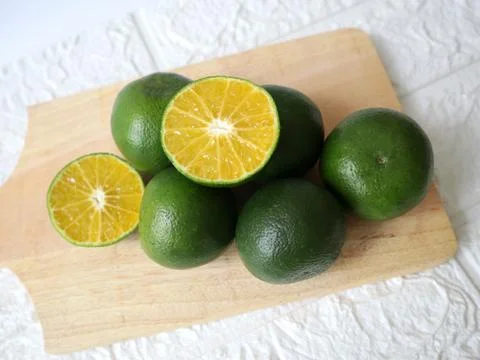 A lime cut in half and placed on a cutting board Stock Photos